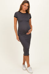 woman wearing a striped black and white maternity dress, showcasing her baby bump with short sleeves and a fitted style