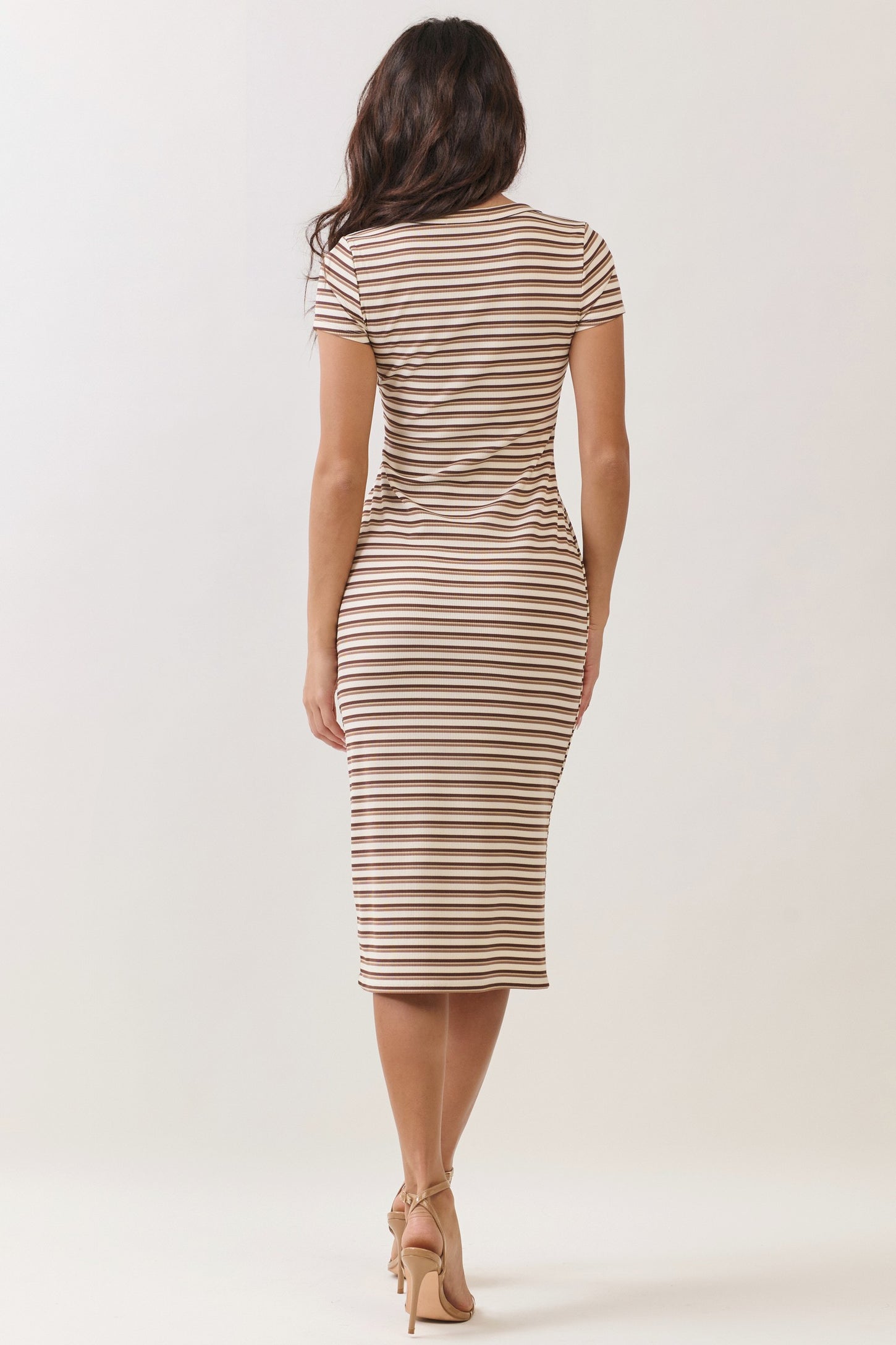 woman wearing a fitted brown and white striped midi dress with short sleeves