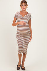woman wearing a brown and white striped maternity dress with short sleeves and a fitted silhouette, holding her baby bump
