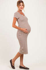 woman wearing a striped maternity dress, showing her baby bump, paired with brown flats