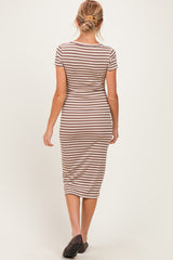 woman wearing a striped brown and cream maternity dress, showing a fitted silhouette and knee-length style from the back