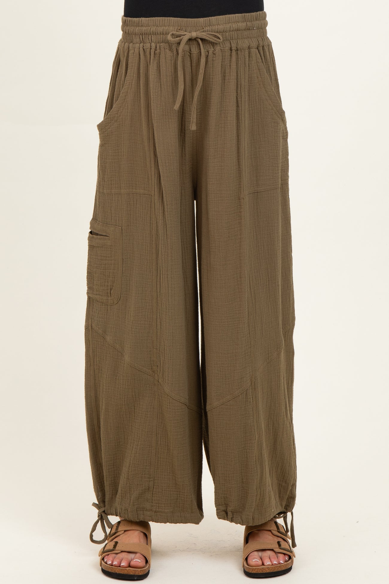 woman wearing olive green maternity wide-leg pants with pockets and adjustable ties at the hem