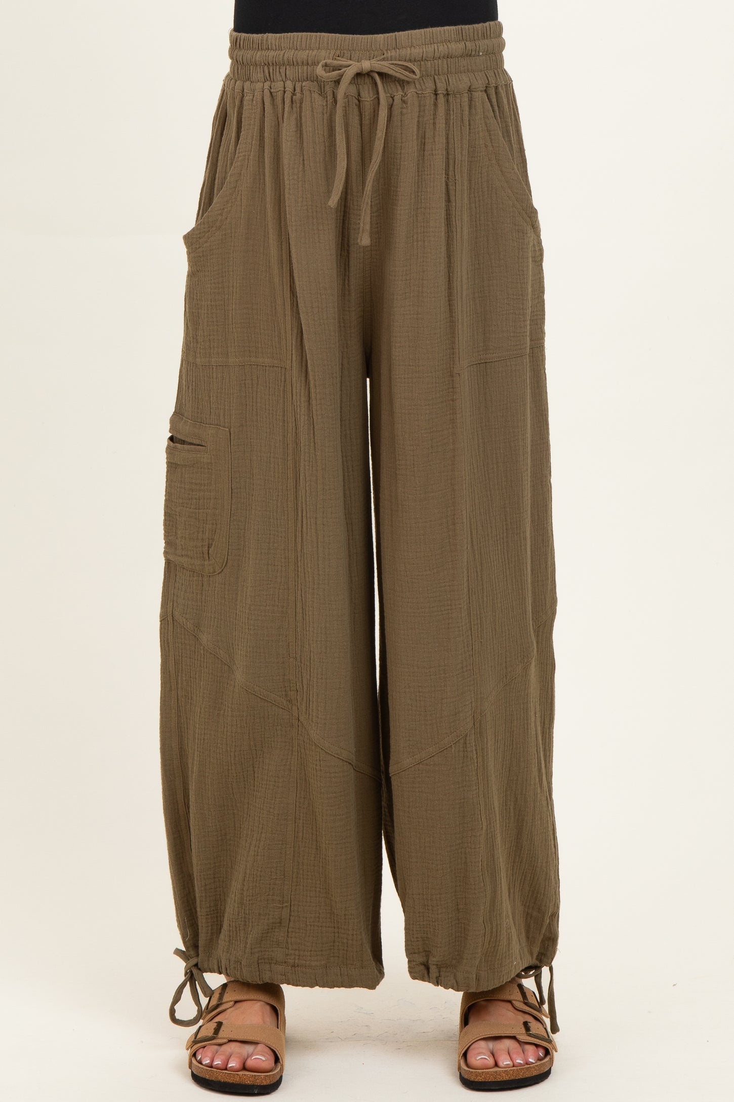 woman wearing olive green maternity wide-leg pants with pockets and adjustable ties at the hem