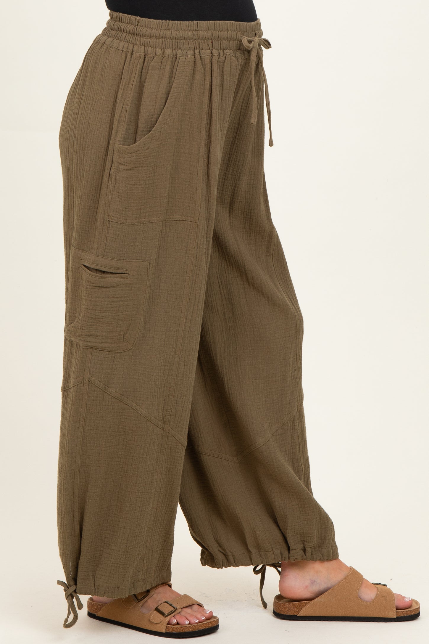 woman wearing olive green maternity wide-leg pants with side pockets and adjustable drawstring hem