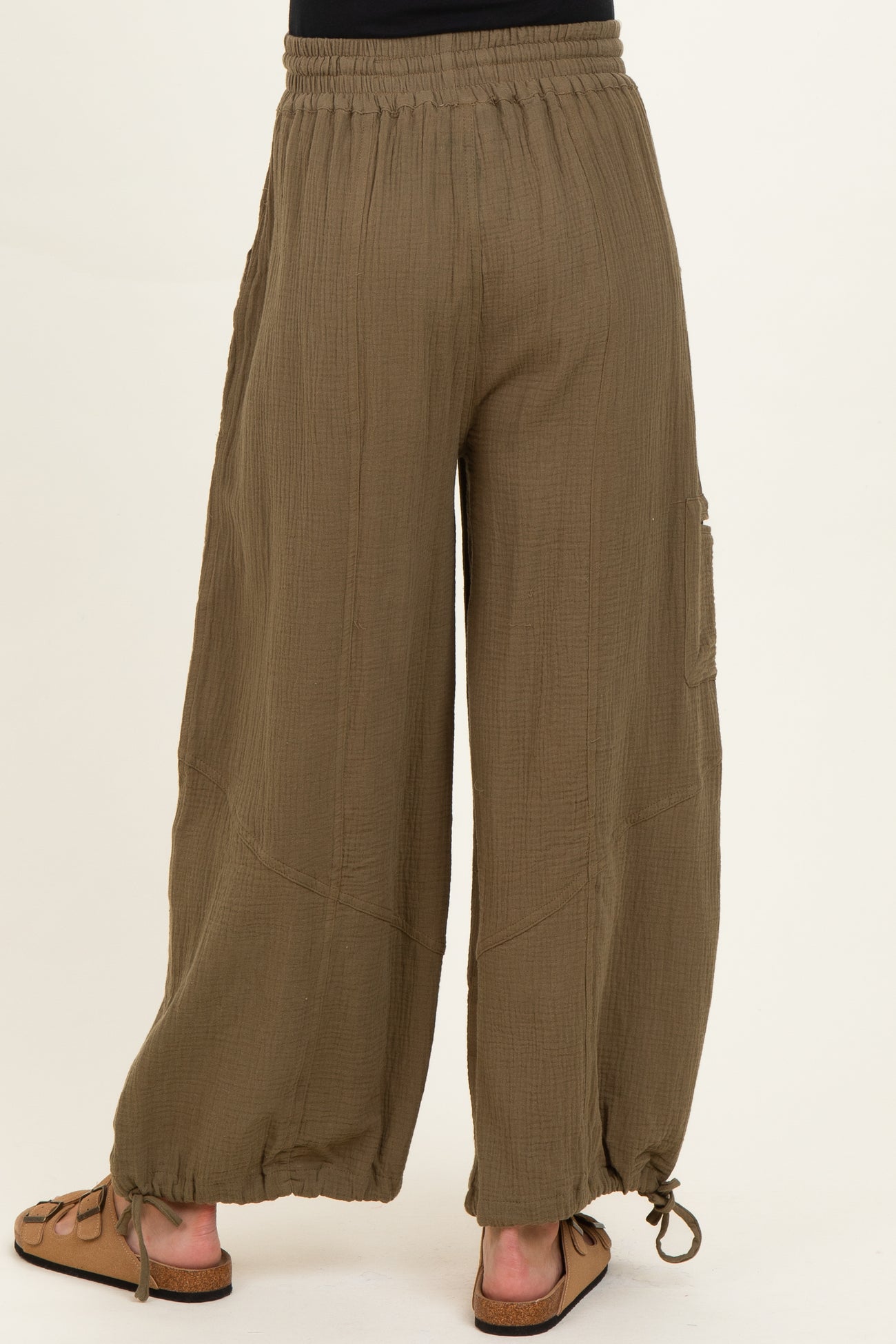 woman wearing olive green maternity wide-leg pants with adjustable drawstring hem and elastic waistband