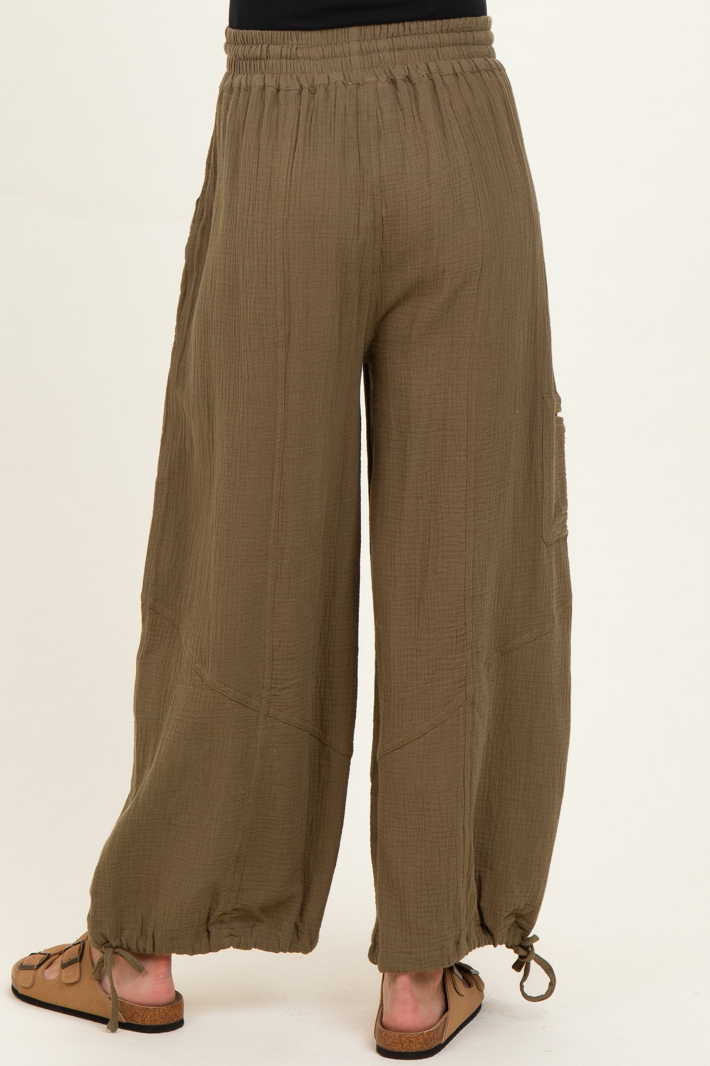 woman wearing olive green maternity wide-leg pants with adjustable drawstring hem and elastic waistband