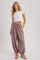 woman wearing a white cropped t-shirt and taupe wide-leg pants with drawstring and side pockets