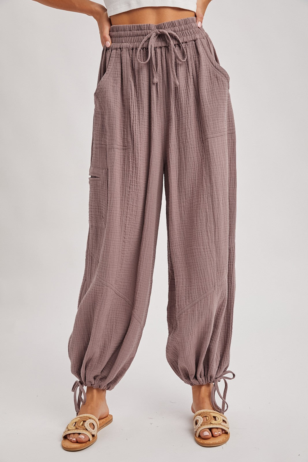 woman wearing loose-fitting mauve textured pants with drawstring waist and gathered cuffs