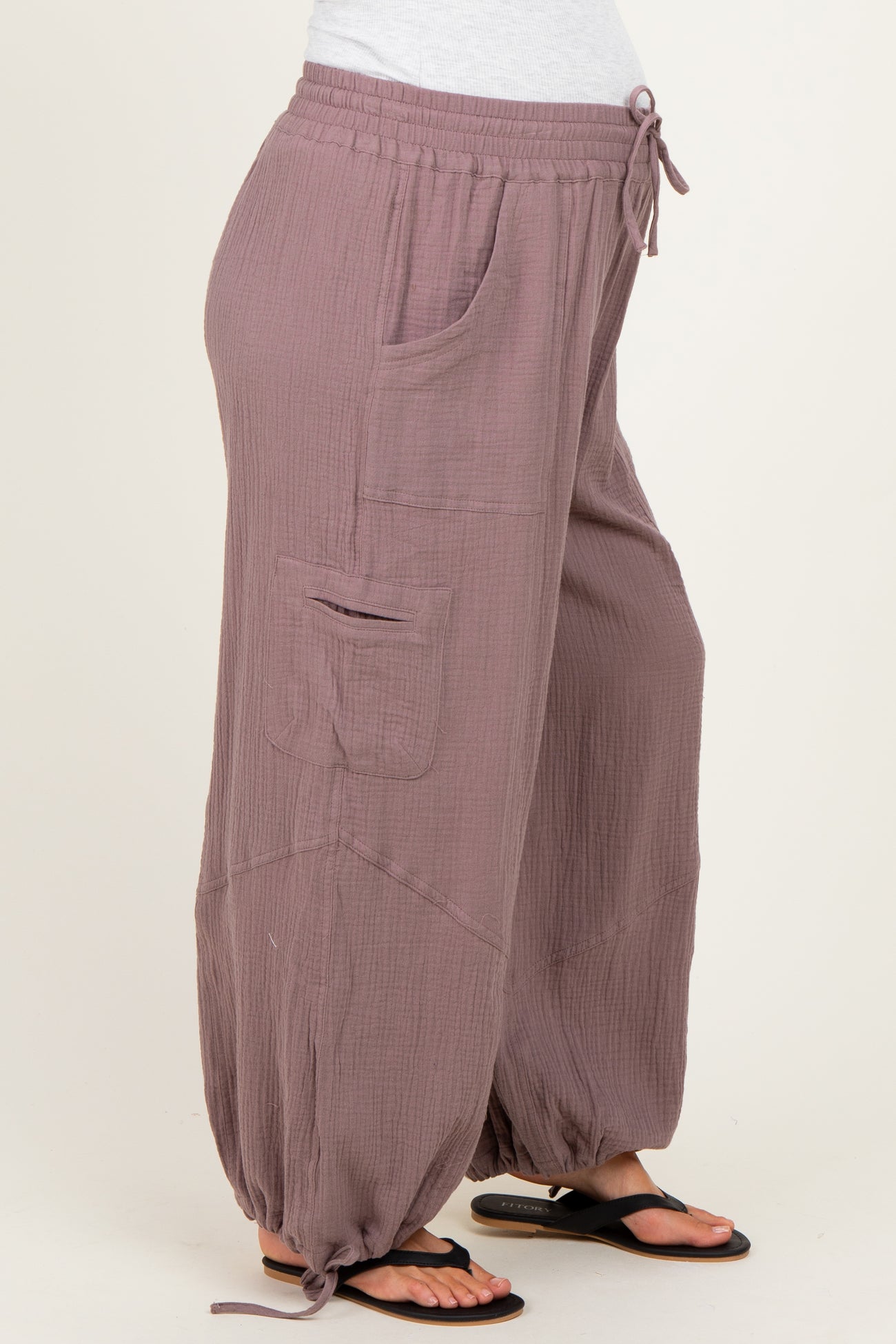 woman wearing mauve maternity jogger pants with pockets and tie detailing at the ankles