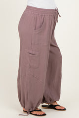 woman wearing mauve maternity jogger pants with pockets and tie detailing at the ankles