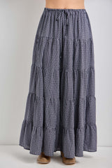 woman wearing a navy and white gingham tiered maxi skirt with a drawstring waist and flared hem