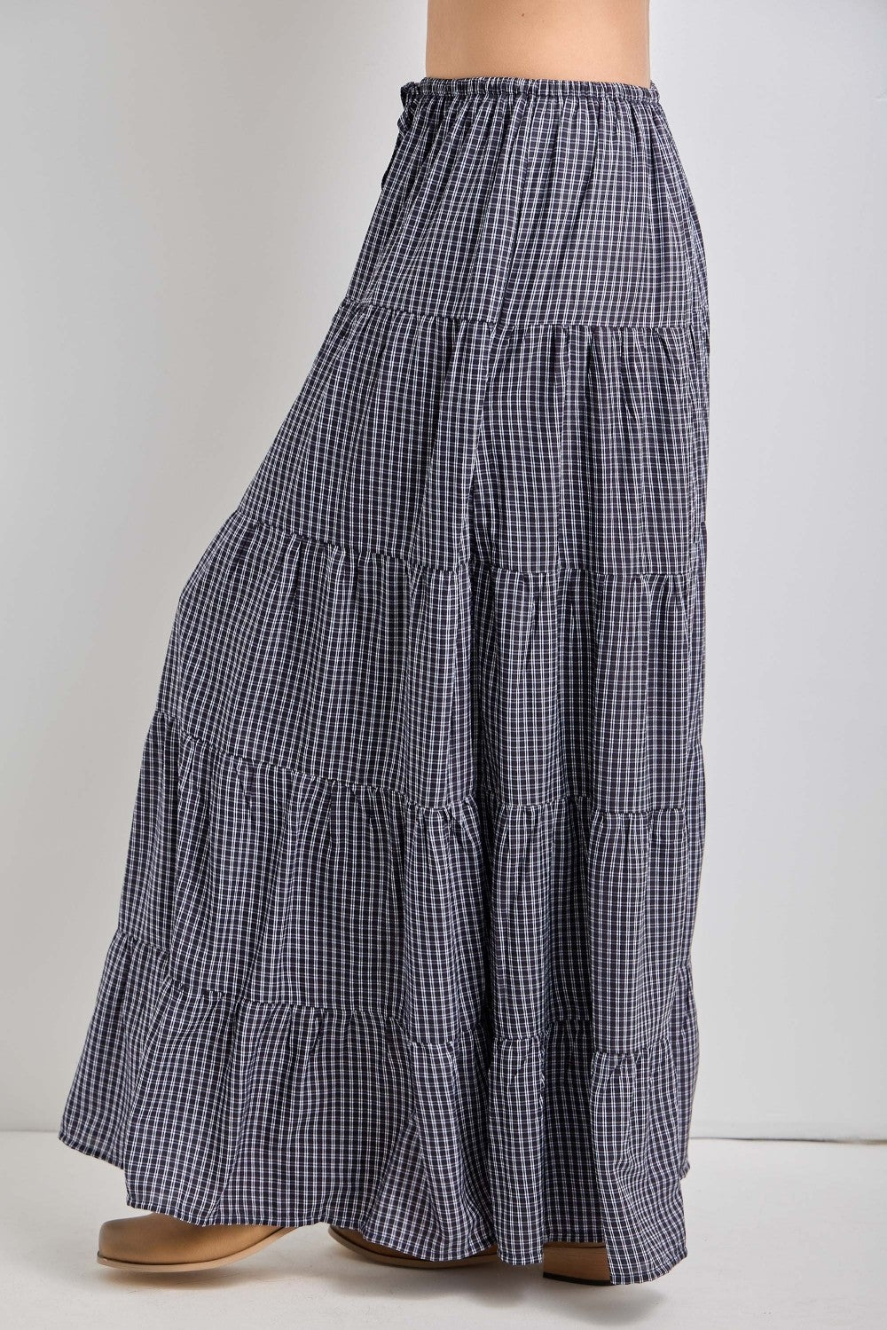woman wearing a navy and white gingham tiered maxi skirt with an elastic waistband