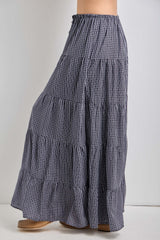 woman wearing a navy and white gingham tiered maxi skirt with an elastic waistband