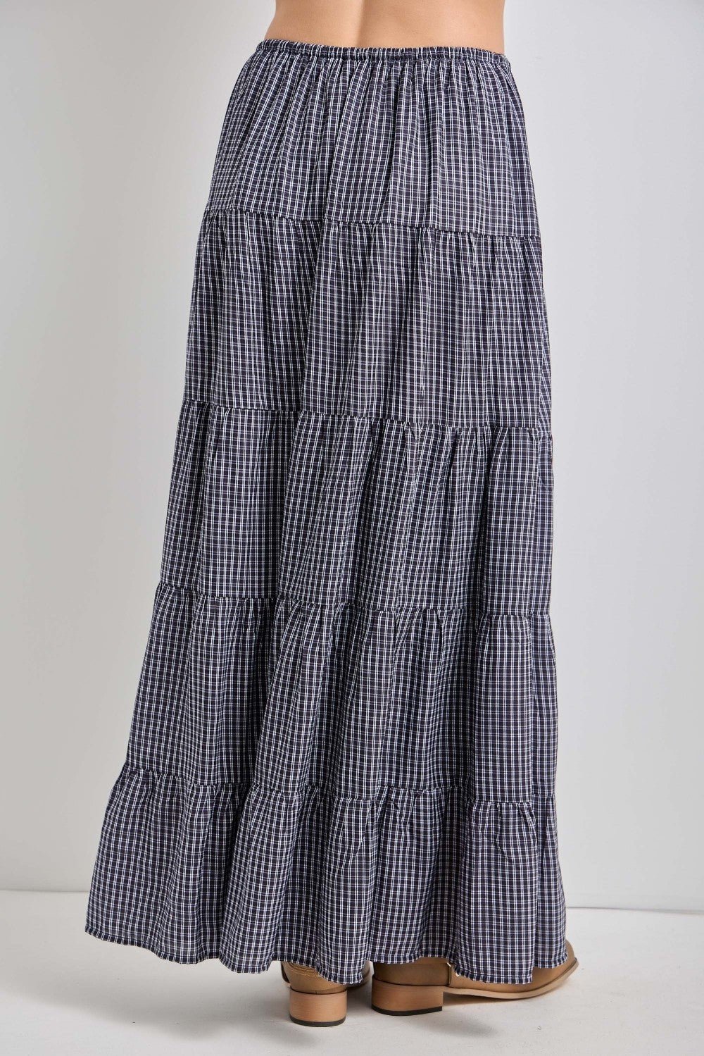 woman wearing a navy and white checked tiered maxi skirt with an elastic waistband