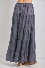 woman wearing a navy and white checked tiered maxi skirt with an elastic waistband