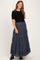 woman wearing a black short sleeve top and a navy and white checkered maternity maxi skirt with tiers