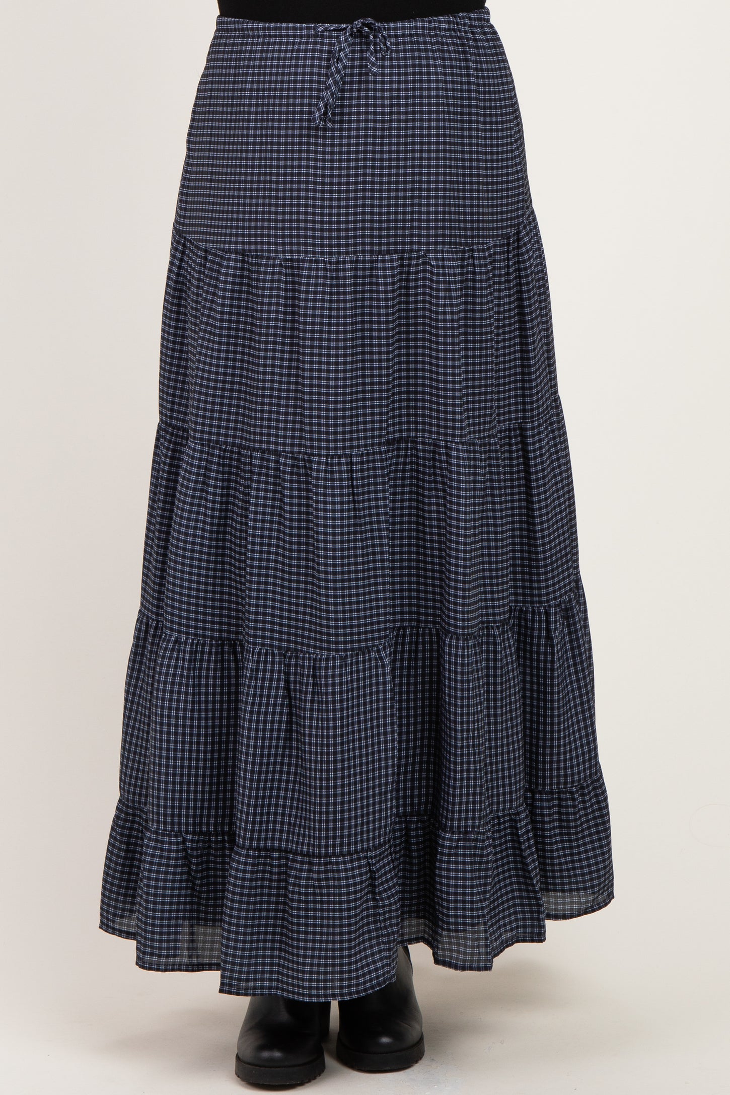 woman wearing a navy and white checked maternity maxi skirt with tiered ruffles and an elastic waistband