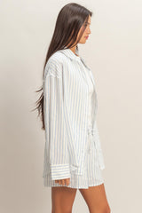 woman wearing a white and blue striped oversized shirt with a drawstring waist and a light tank top underneath