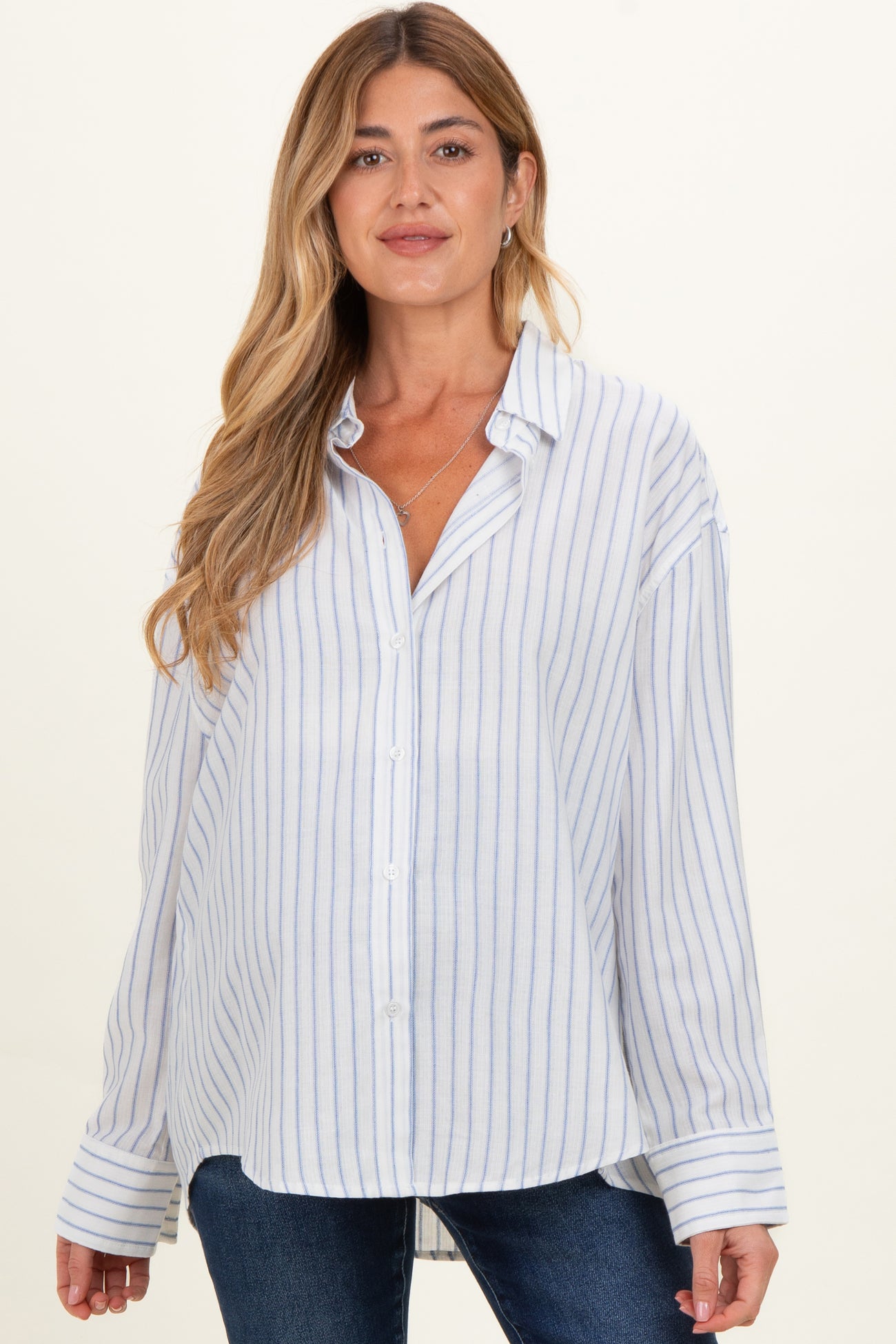 woman wearing a white and blue striped maternity shirt with a button-down front and relaxed fit