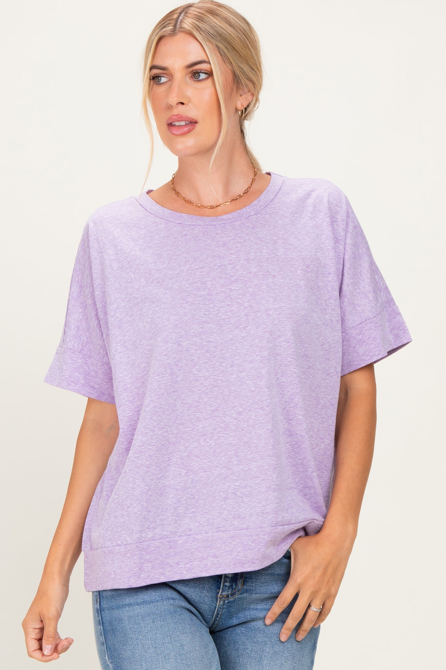 woman wearing a lavender short sleeve relaxed fit t-shirt paired with denim jeans