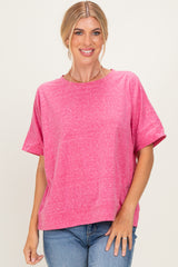 woman wearing a bright pink short sleeve top with a relaxed fit and round neckline, styled with blue jeans