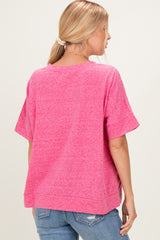 woman wearing a pink oversized short sleeve shirt with a relaxed fit and back seam detail, paired with blue jeans