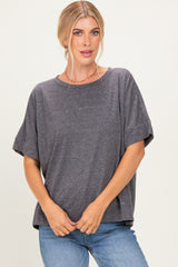 woman wearing a dark gray oversized t-shirt with short sleeves and a relaxed fit, paired with blue jeans
