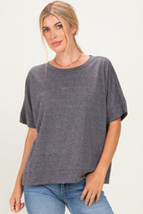 woman wearing a gray oversized short sleeve top with a relaxed fit and rolled sleeves, paired with blue jeans