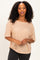 woman wearing a beige oversized short sleeve t-shirt with a scoop neckline and textured fabric