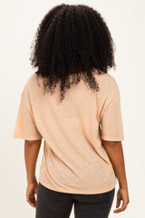 woman wearing a light peach short sleeve top, viewed from the back, paired with dark jeans