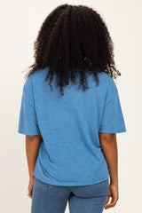 woman wearing a blue oversized short sleeve t-shirt and blue jeans, viewed from the back