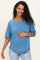woman wearing a blue maternity top with short sleeves and holding her baby bump