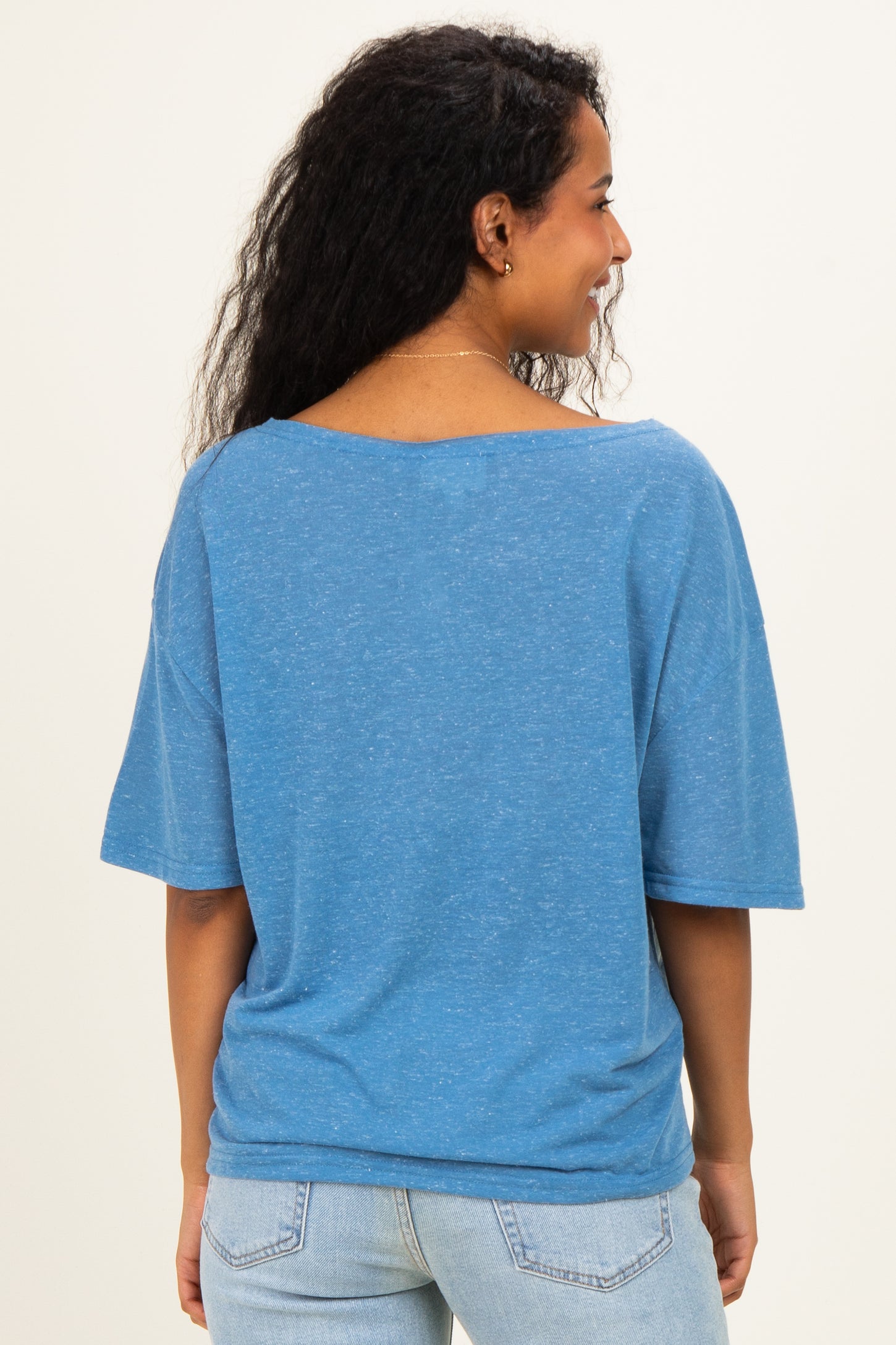 woman wearing a blue short sleeve maternity top seen from the back with a relaxed fit