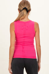 woman wearing a bright pink maternity tank top, viewed from the back, with a fitted and stretchy design