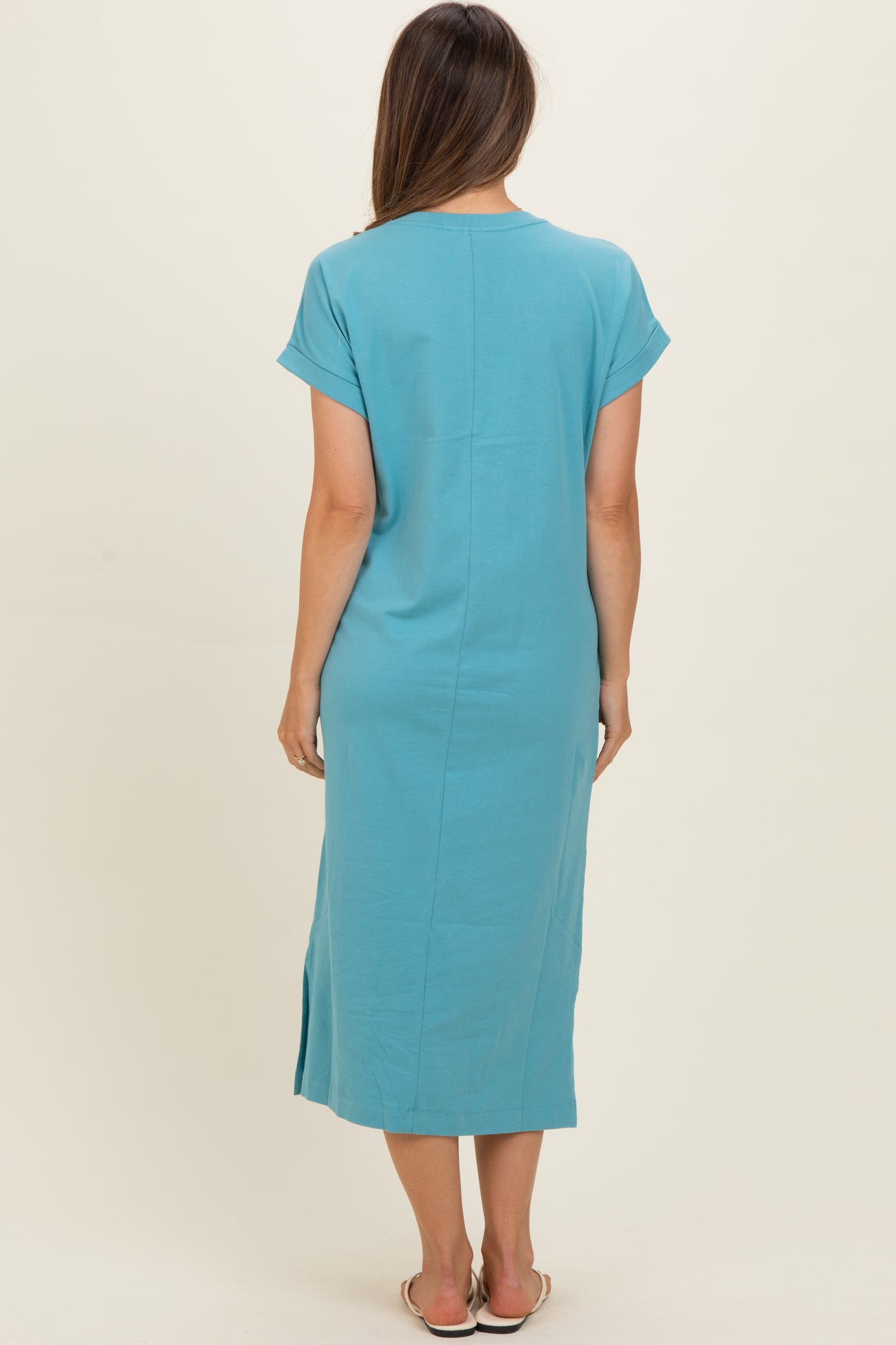 woman wearing a light blue maternity dress with short sleeves and a side slit, shown from the back