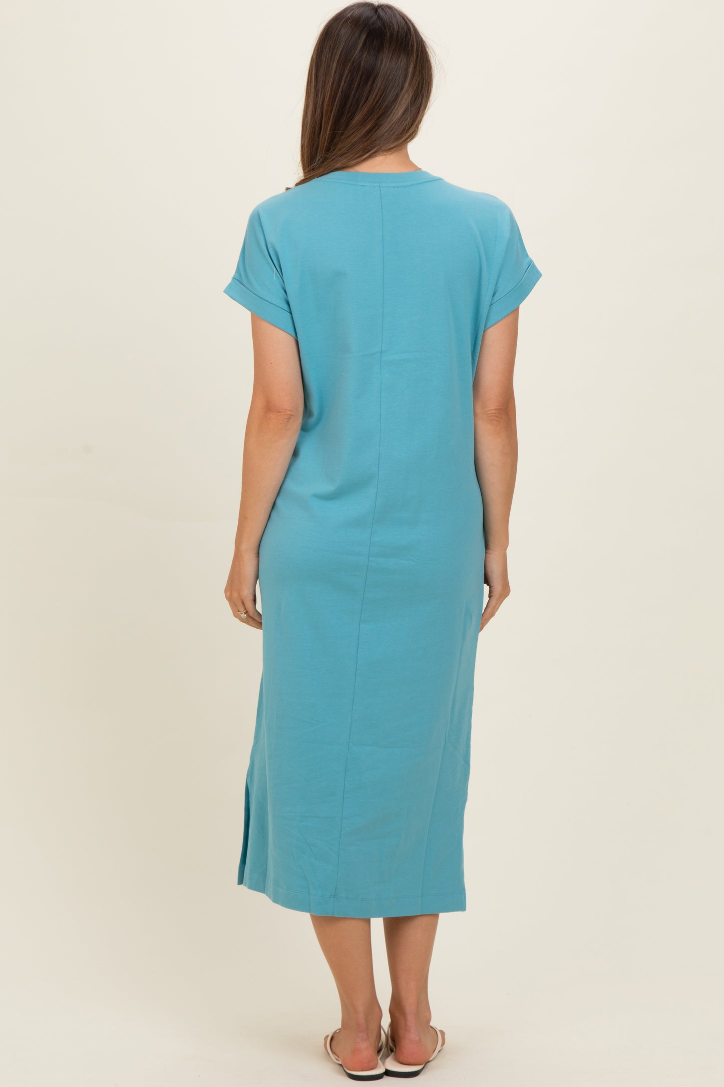 woman wearing a light blue maternity dress with short sleeves and a side slit, shown from the back