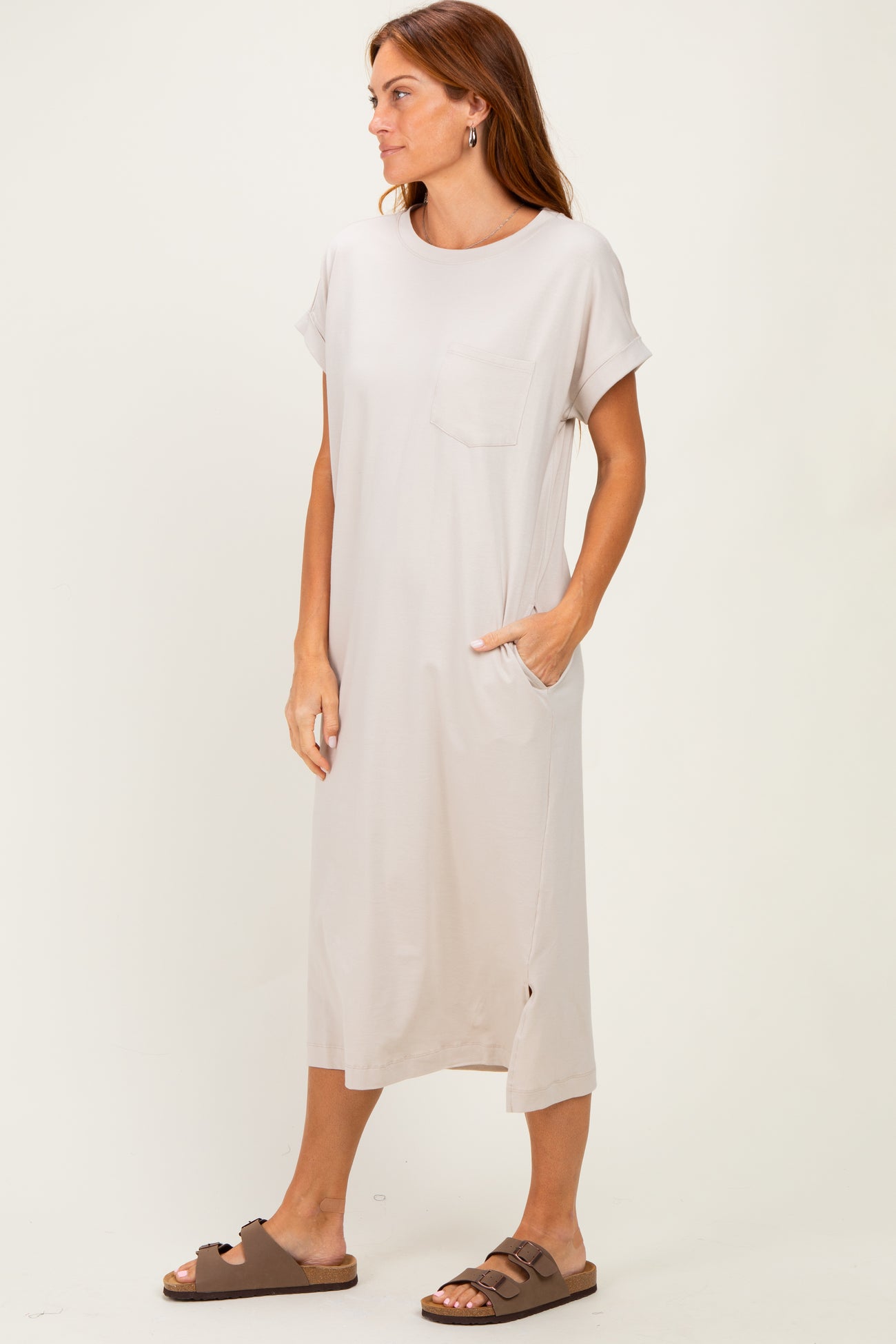woman wearing a light beige short sleeve midi dress with side pockets and a chest pocket