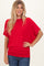 woman wearing a red short sleeve top with a loose fit and smiling at the camera