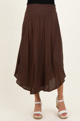 woman wearing a brown maternity maxi skirt with a smocked waist and flowy silhouette