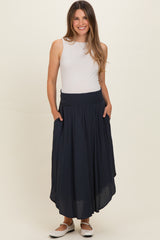 woman wearing a navy blue maternity maxi skirt with pockets and a smocked waistband