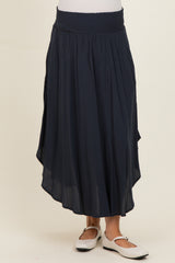 maternity wear navy blue flowy skirt with a smocked waistband, model wearing it with a relaxed fit.