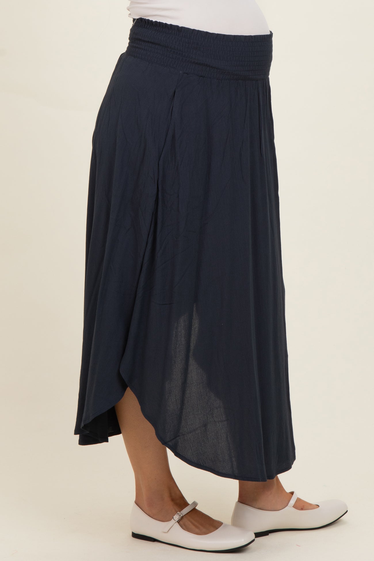 woman wearing a dark blue maternity maxi skirt with a smocked waist and asymmetrical hem
