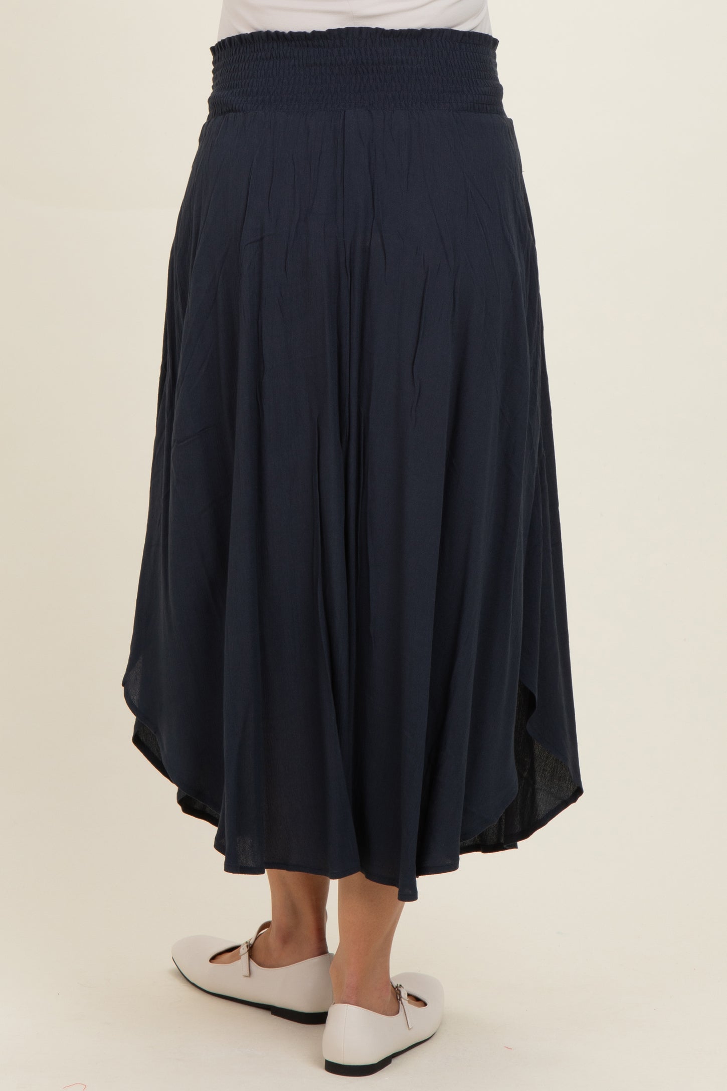 maternity wear navy blue maxi skirt with a smocked waistband and high-low hem, model showing the back view