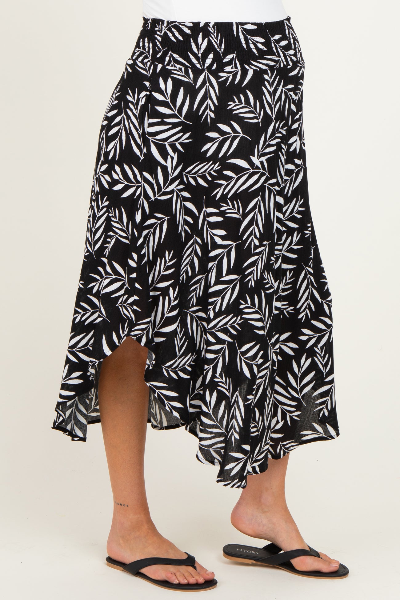 maternity wear black and white leaf patterned asymmetrical skirt worn by a model with bare feet
