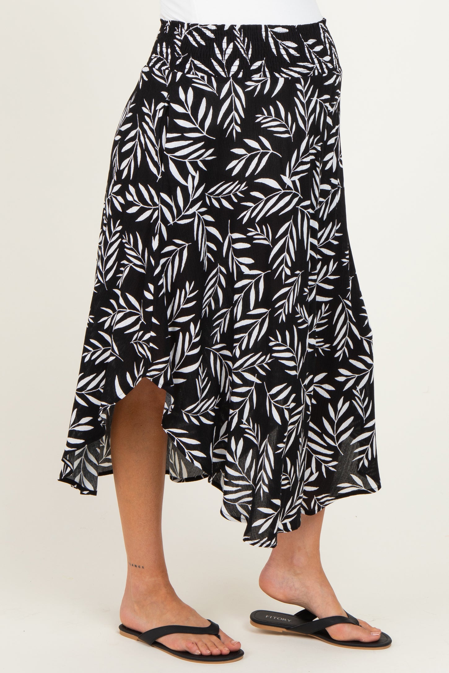 maternity wear black and white leaf patterned asymmetrical skirt worn by a model with bare feet