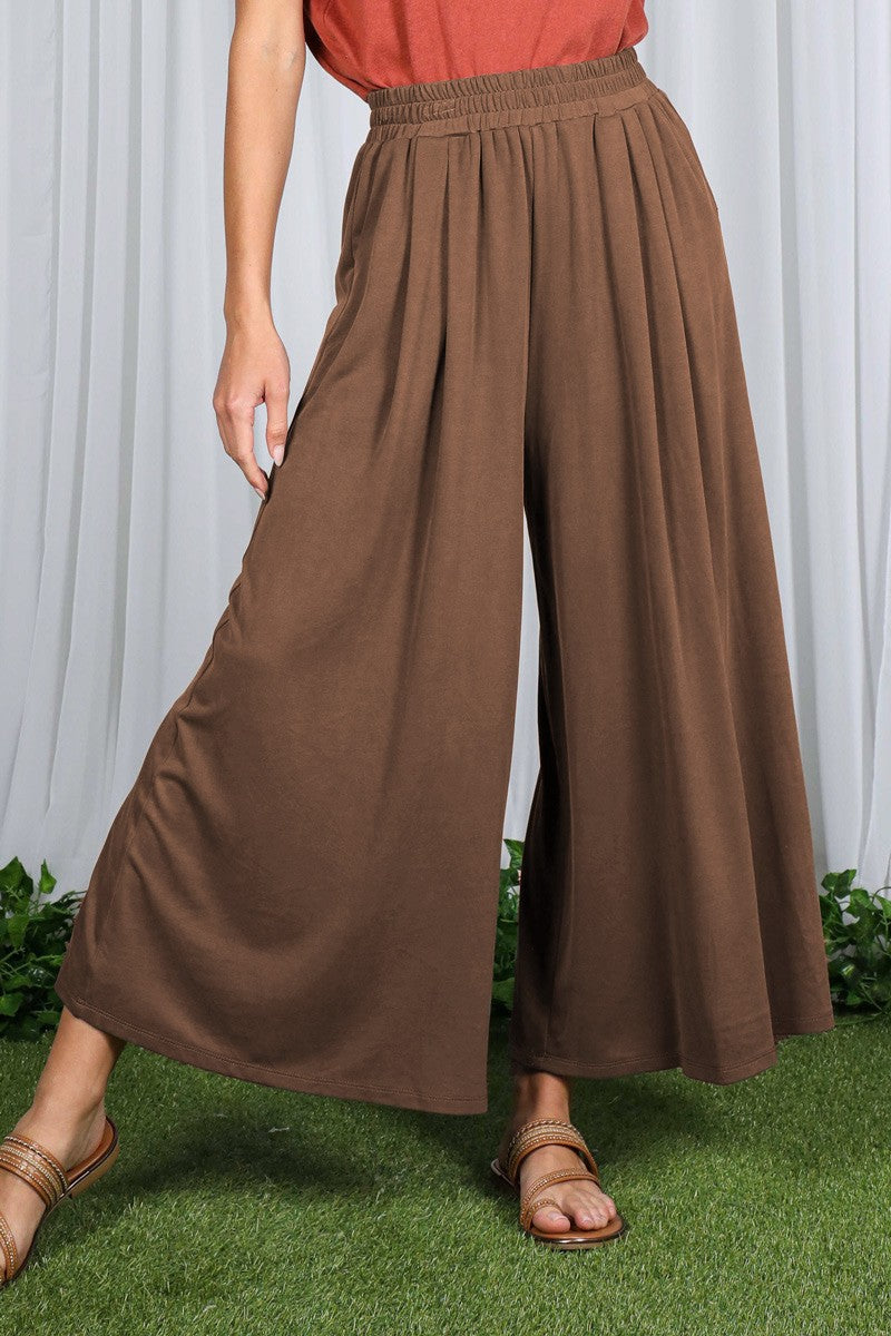 woman wearing brown wide-leg pants with an elastic waistband and styled with a rust-colored top