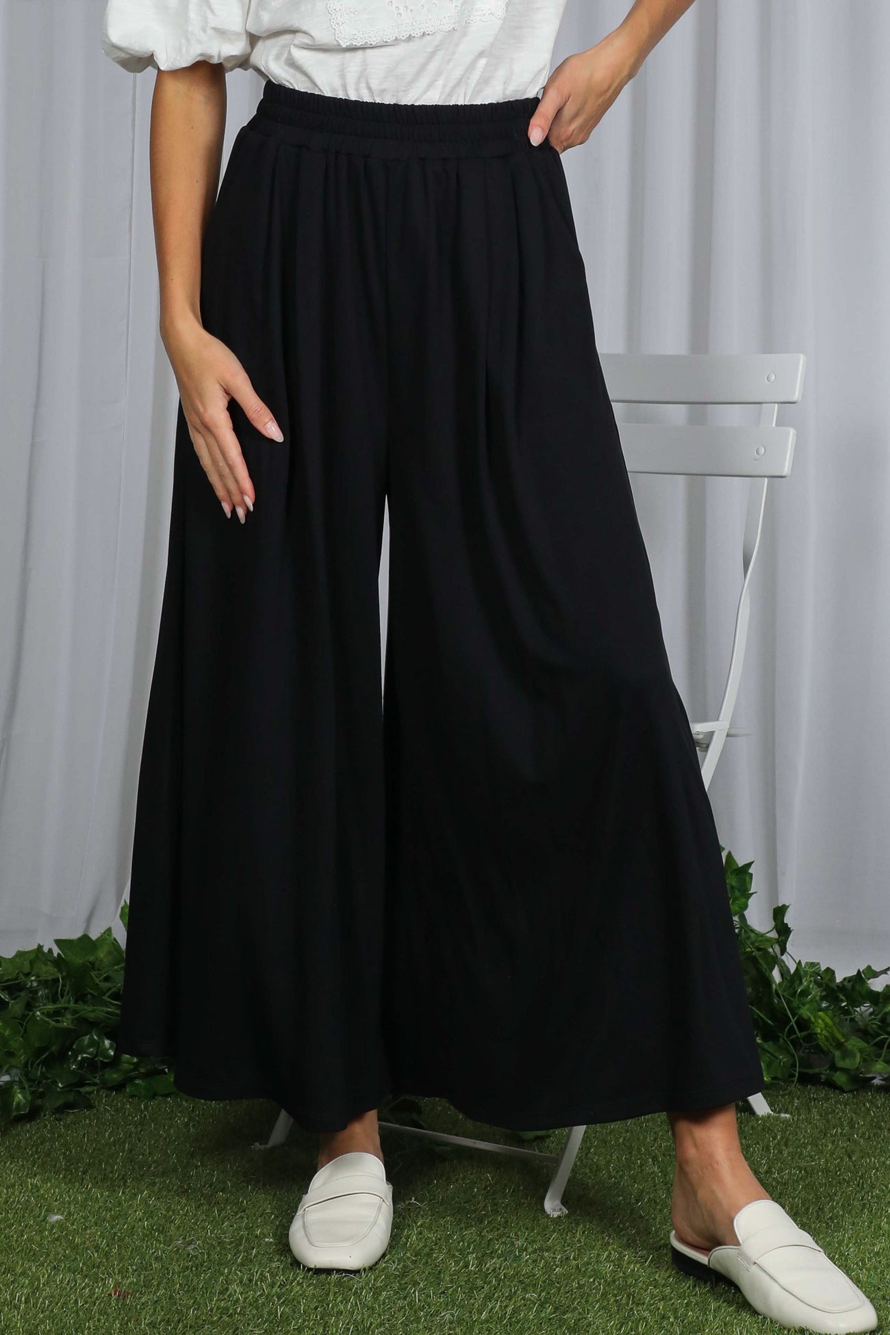woman wearing black wide-leg trousers with an elastic waistband and flowy fabric