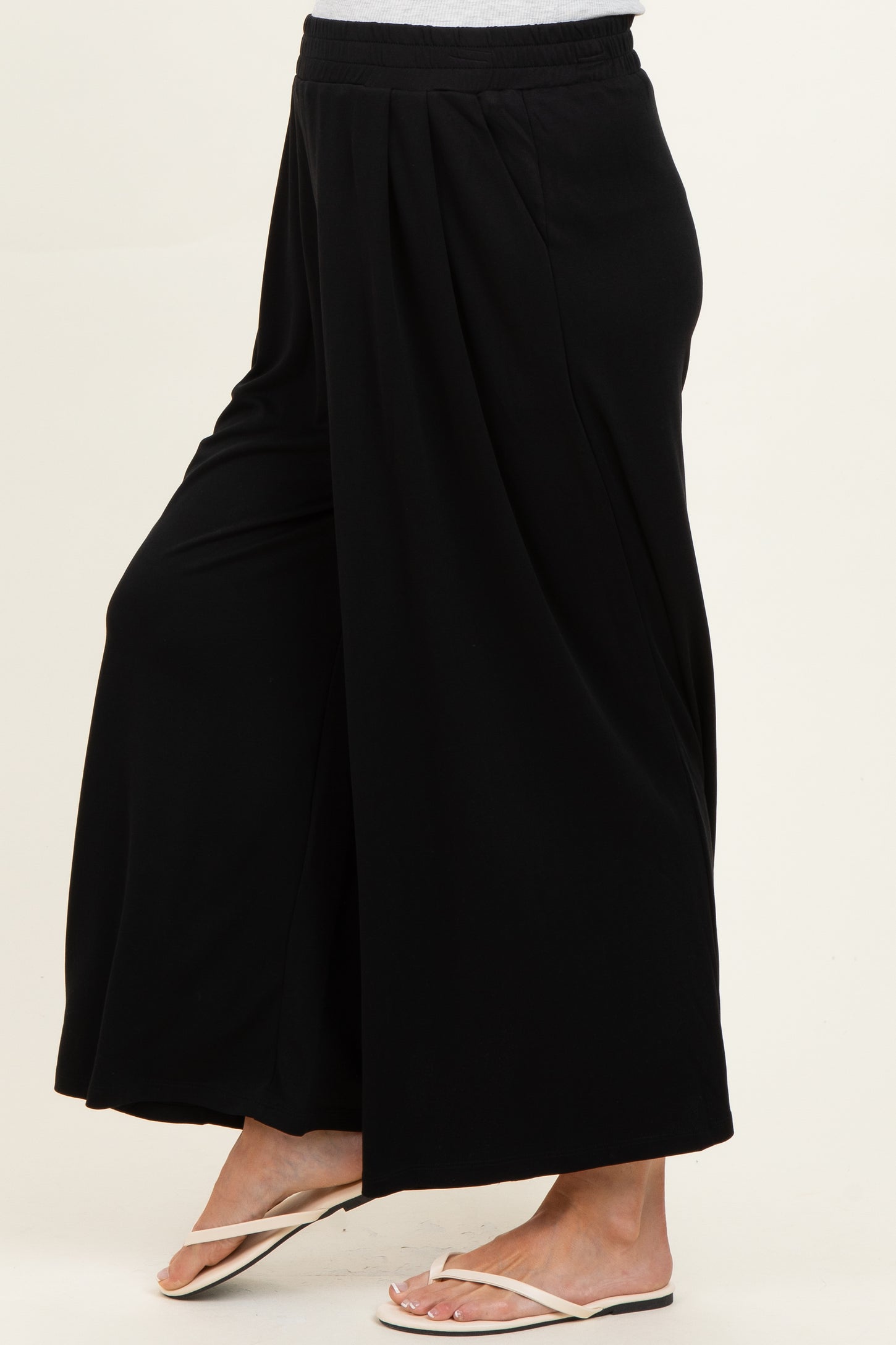 woman wearing black wide-leg maternity pants with a loose fit and elastic waistband