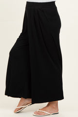 woman wearing black wide-leg maternity pants with a loose fit and elastic waistband