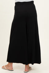 woman wearing black maternity wide-leg pants, showing the back view and comfortable elastic waistband